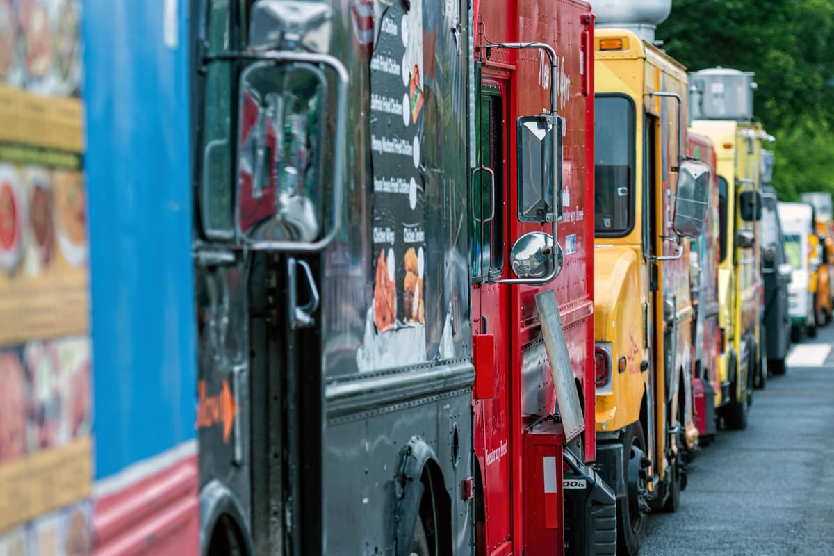 A row of food trucks parked side by side at an event